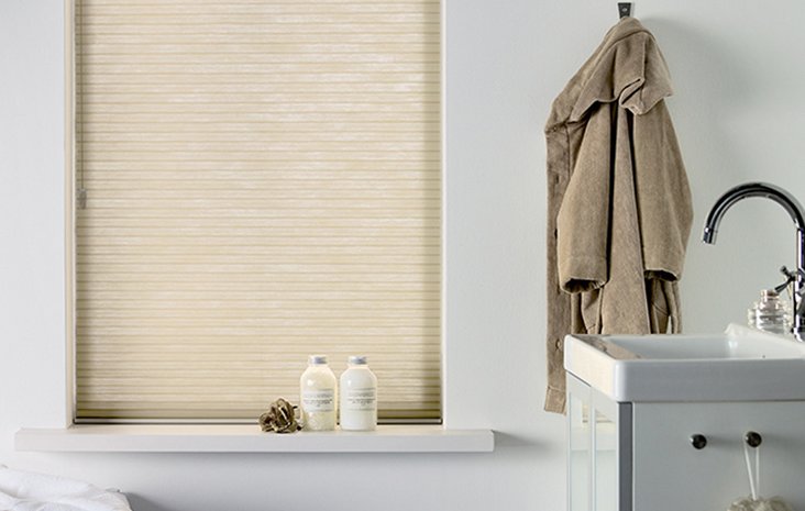 Kadeco Wabenplissee beige Helles Badezimmer mit asymmetrischem Fenster, das mit einem beigen Kadeco Wabenplissee bedeckt ist.