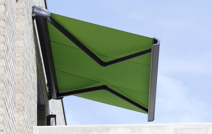 Grüne Markise Grüne Markise ist an der Außenwand eines Gebäudes montiert, schützt vor Sonne und spendet Schatten.